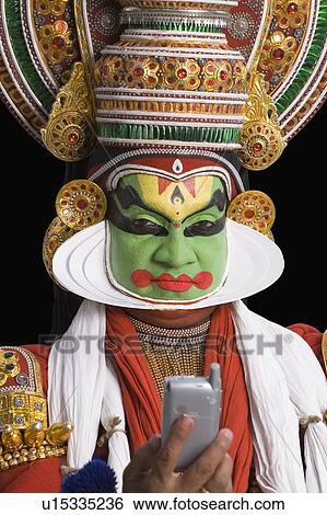 Portrait of a Kathakali dance performer holding a mobile phone View Large Photo Image Stock Photograph - Portrait of a Kathakali dance performer holding a mobile phone. Fotosearch