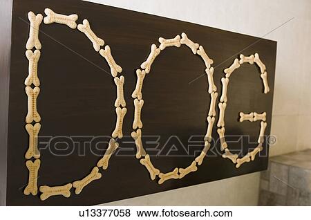 Stock Photo - Close-up of text DOG made with dog biscuits on a blackboard. Fotosearch
