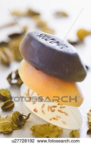 Stock Image - Close-up of a stack of soaps with herbs. Fotosearch