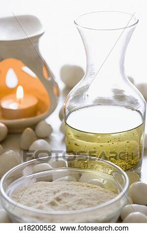 Stock Image - Close-up of an aromatherapy candle burning with aromatherapy products. Fotosearch