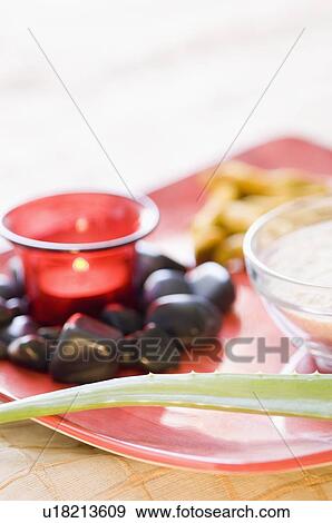 Stock Photo - Close-up of an aromatherapy candle burning with black pebbles. Fotosearch