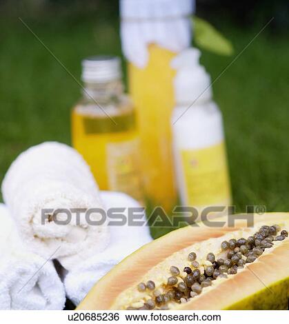 Stock Photograph - Close-up of papaya massage therapy treatment products on the grass. Fotosearch