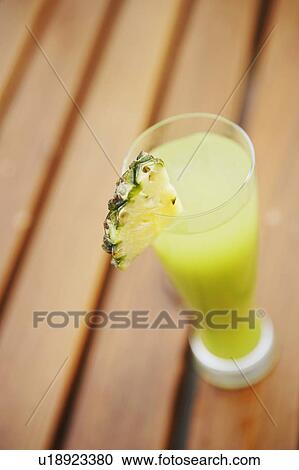High angle view of a glass of pineapple juice on a bench View Large Photo Image Stock Image - High angle view of a glass of pineapple juice on a bench. Fotosearch