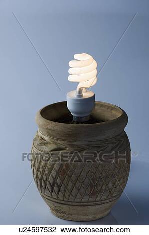Stock Image - Close-up of a lit energy efficient light bulb in a pot. Fotosearch