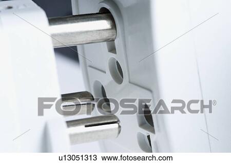 Stock Image - Close-up of a three pin plug with an electric socket. Fotosearch