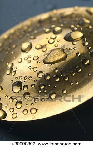 Stock Image - Close-up of water drops on a metal surface. Fotosearch