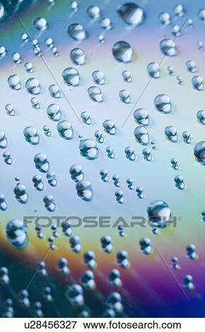 Stock Photo - Close-up of water drops on a multi-colored surface. Fotosearch