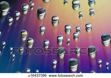 Stock Photograph - Close-up of water drops on a multi-colored surface. Fotosearch