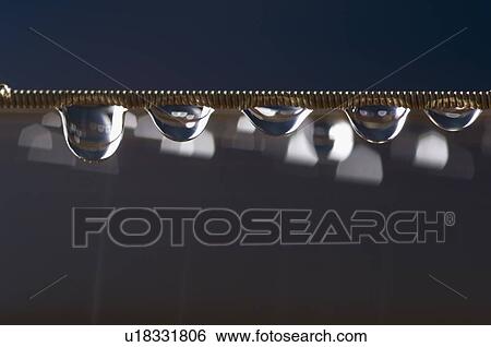 Stock Photograph - Close-up of water drops on a string. Fotosearch