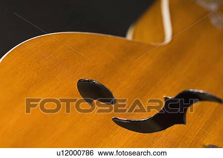 Close-up of holes on a guitar View Large Photo Image Stock Photograph - Close-up of holes on a guitar. Fotosearch