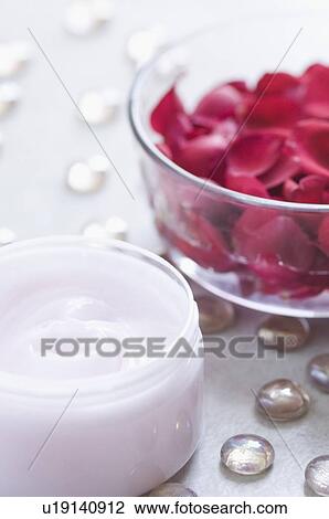 Stock Image - Close-up of rose petals in a bowl with moisturizer. Fotosearch