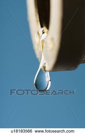 Stock Photograph - Close-up of a water drop dripping from a faucet. Fotosearch