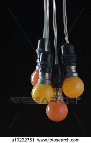 Stock Image - Four light bulbs hanging on wires. Fotosearch