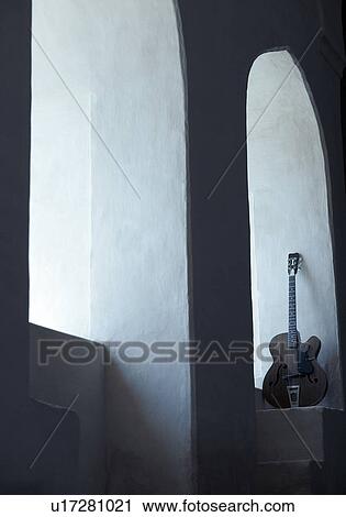 Stock Image - Guitar under an arch. Fotosearch
