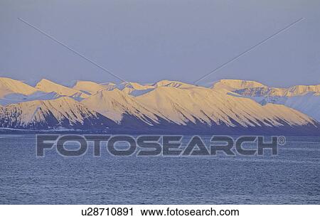 Stock Image - Pinkish evening sun on the mountain slopes of Northern Spitsbergen. . Fotosearch