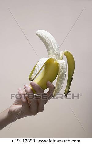 Woman's hand holding peeled banana (close-up) View Large Photo Image Stock Image - Woman's hand holding peeled banana (close-up). Fotosearch
