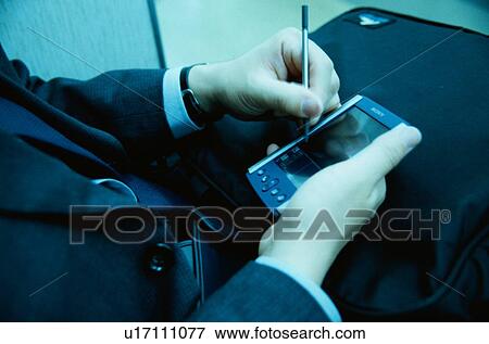 Stock Photo - Man Using Handheld Computer. Fotosearch