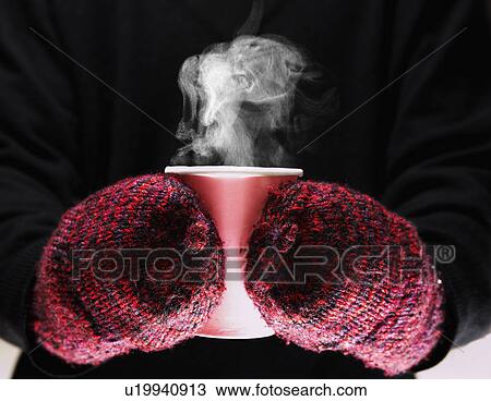 Stock Image - Person with Mittens Holding Hot Drink. Fotosearch