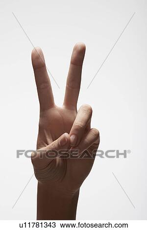 Stock Image - Woman's hand making 'peace' sign (close-up). Fotosearch