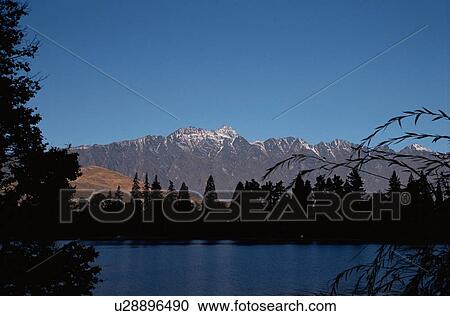 Stock Image - Mountains Behind Trees. Fotosearch
