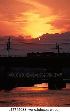 Stock Image - Train On Bridge In Sunset. Fotosearch