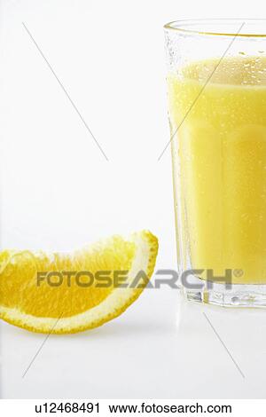 Slice of orange beside glass of orange juice View Large Photo Image Stock Image - Slice of orange beside glass of orange juice. Fotosearch