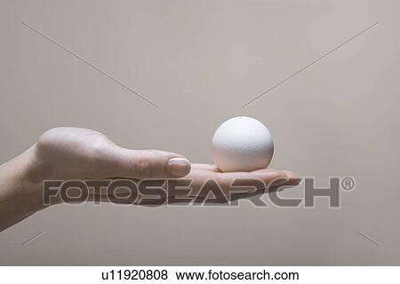 Stock Photo - Woman's hand holding egg. Fotosearch