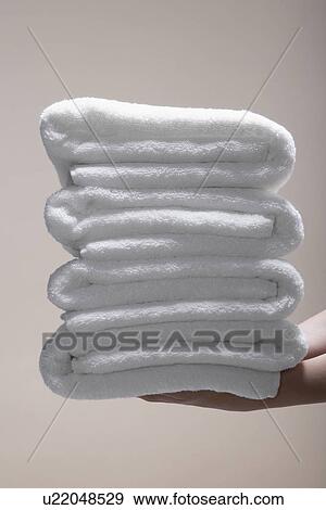 Woman's hands holding stack of folded towels (close-up) View Large Photo Image Stock Photo - Woman's hands holding stack of folded towels (close-up). Fotosearch