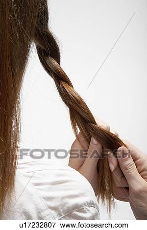 Young woman tying her hair (rear view) View Large Photo Image Stock Photo - Young woman tying her hair (rear view). Fotosearch