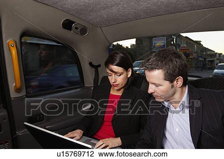 Business couple with laptop in taxi View Large Photo Image Stock Image - Business couple with laptop in taxi. Fotosearch