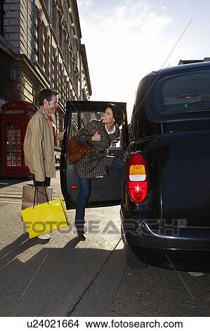 Picture - Couple entering London taxi. Fotosearch