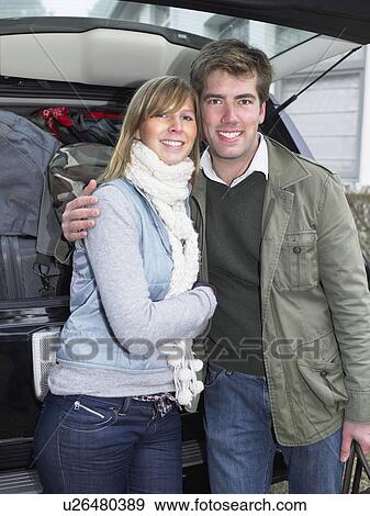 Couple in front of packed car View Large Photo Image Stock Photo - Couple in front of packed car. Fotosearch