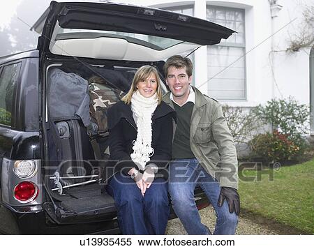 Stock Photography - Couple in front of packed car. Fotosearch