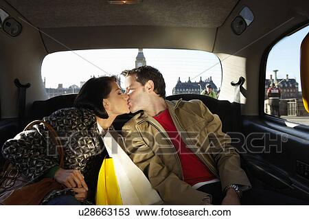 Stock Image - Couple kissing in London taxi. Fotosearch