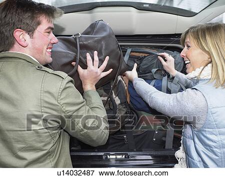 Couple packing car View Large Photo Image Stock Photo - Couple packing car. Fotosearch