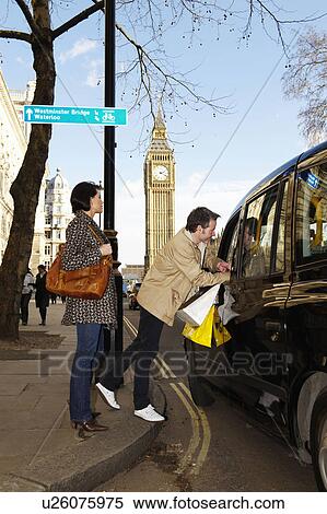 Stock Photography - Couple with London taxi, Big Ben behind . Fotosearch