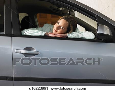 Girl (12-14) sitting in car, leaning on open window, portrait View Large Photo Image Stock Image - Girl (12-14) sitting in car, leaning on open window, portrait. Fotosearch