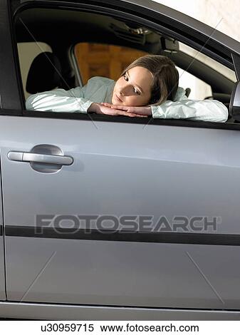 Stock Photography - Girl (12-14) sitting in car, leaning on open window. Fotosearch