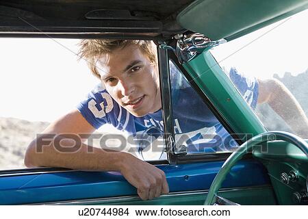 Picture - Man leaning into car.. Fotosearch