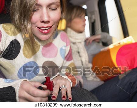 Young woman painting nails in car View Large Photo Image Stock Photo - Young woman painting nails in car. Fotosearch