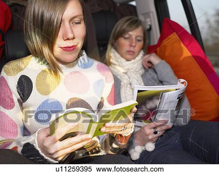 Stock Photography - Young women reading in car. Fotosearch
