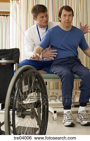 Physical Therapist Helping Wheelchair Bound Man Stock Photograph