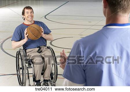 Wheelchair Bound Man Passing Basketball To Friend Stock Image