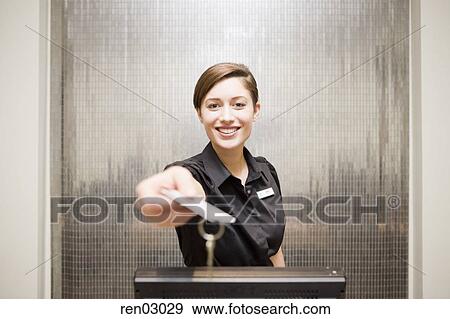 Female Hotel Front Desk Clerk Handing Keycard Stock Photo