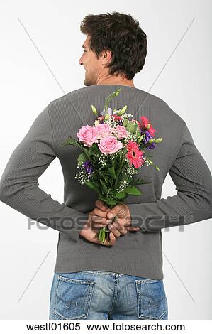 Jeune Homme Tenue Bouquet Fleurs Derrière Dos Sourire Vue Postérieure Banques De Photographies