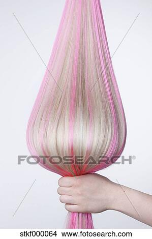 人間の術中 保有物 ブロンドの髪 で ピンク ハイライト に対して 白い背景 終わり ピクチャー Stkf Fotosearch