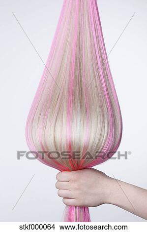 Human Hand Holding Blond Hair With Pink Highlights Against White