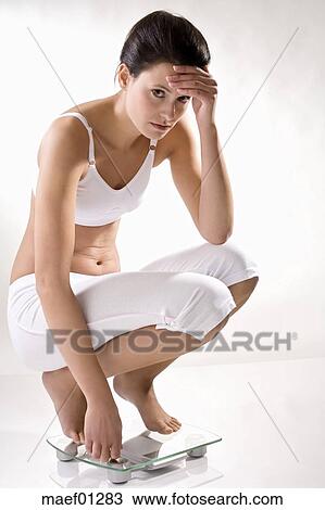 若い女性 しゃがむ 上に スケール 先頭に立つべき術中 ストックイメージ Maef012 Fotosearch