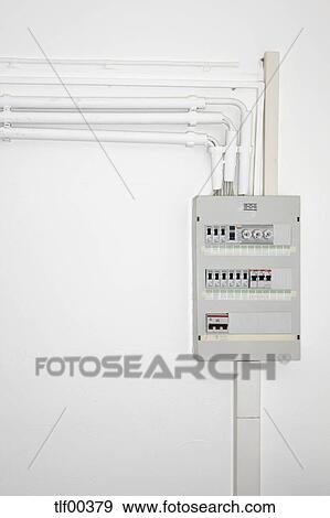 stock photograph of pipes, electric cables and fuse box on white Fuse Box Wiring pipes, electric cables and fuse box on white wall