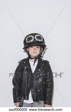 Portrait of little rocker boy wearing leather jacket, motorcycle helmet ...